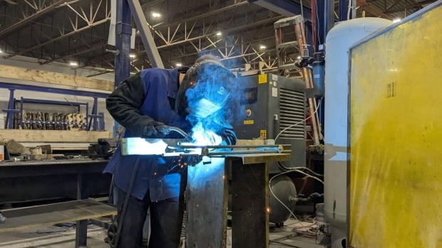 A welder at Avac Beton in Granby, Que. The business, found 43 years ago, has shifted to making prefabricated components for housing projects. a welder at work