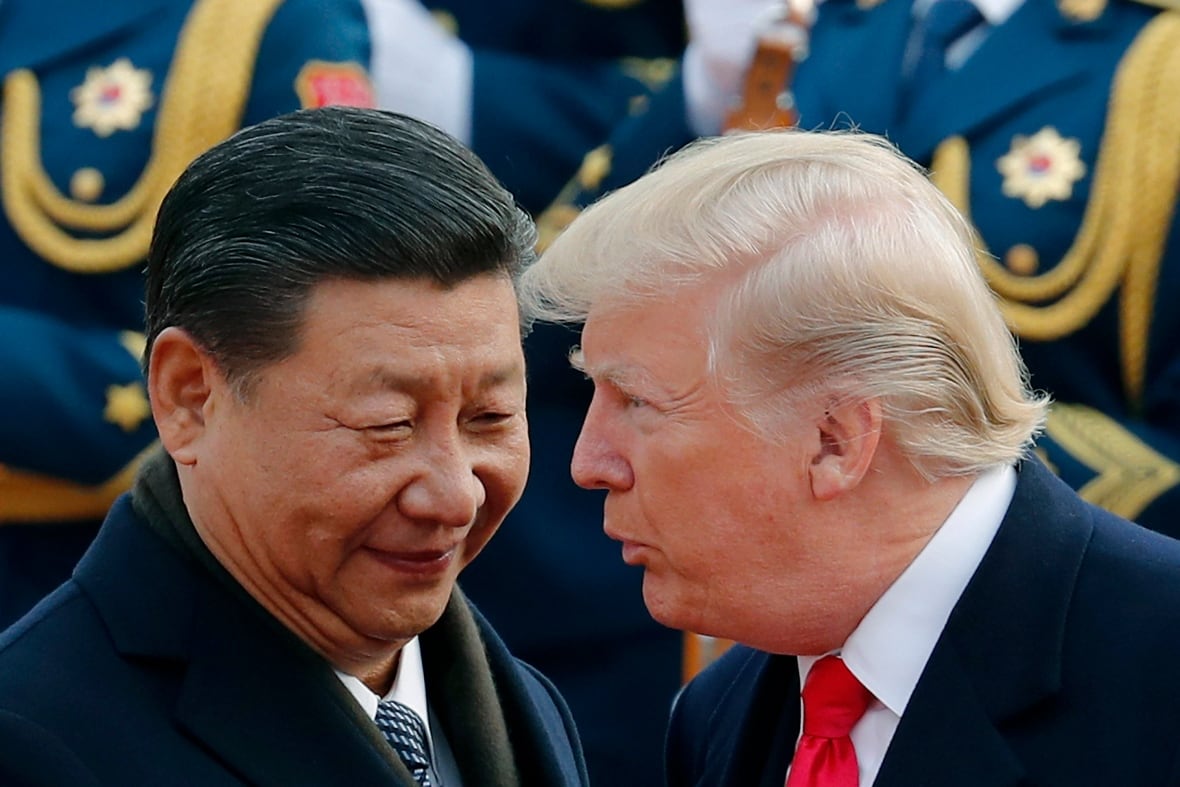 Two men in suits face each other, one speaking to the other