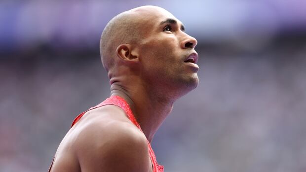 An men's athletics competitor is shown at side profile view, with only his head and shoulders visible.