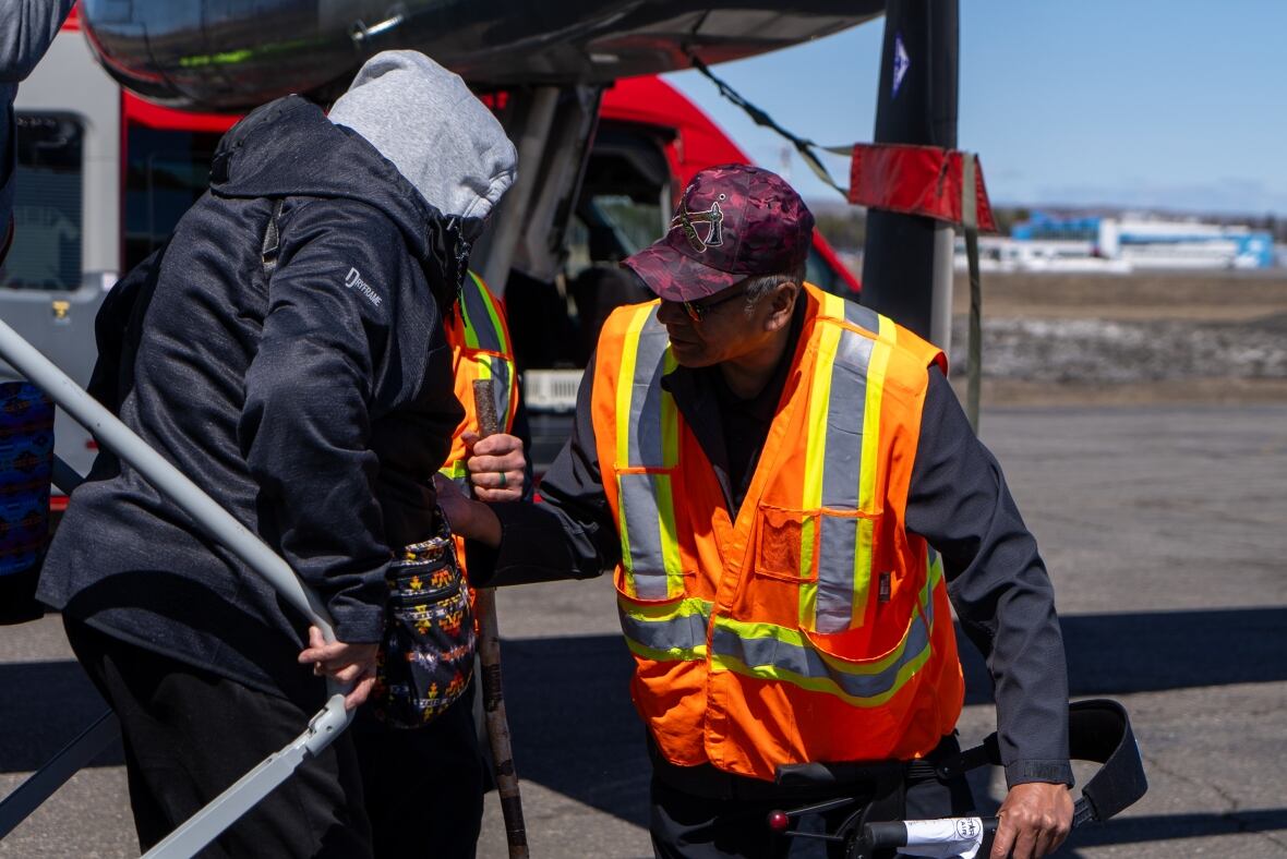 Una camisa de seguridad es un hombre que puede ayudar a una mujer con una caña de azúcar del avión.