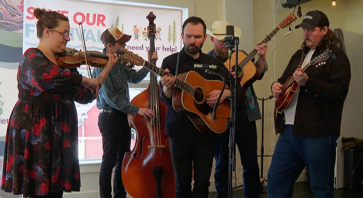 Group of people playing instruments in front of microphone