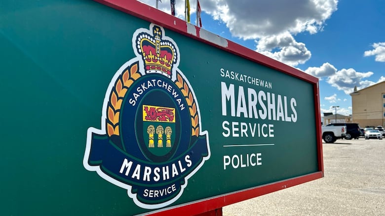 The logo of the Saskatchewan Marshals Service is shown on a sign in front of a building.