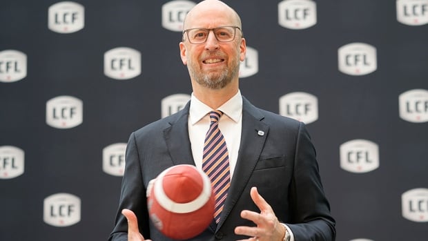 Canadian Football League commissioner Stewart Johnston poses with a football following his introductory media press conference at Hotel X in Toronto on April 24, 2025. 
