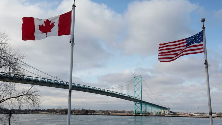 A Canadian and a U.S. flag fly next to the Ambassador Bridge towards Detroit from Windsor, Ontario, Canada, February 1, 2025. 