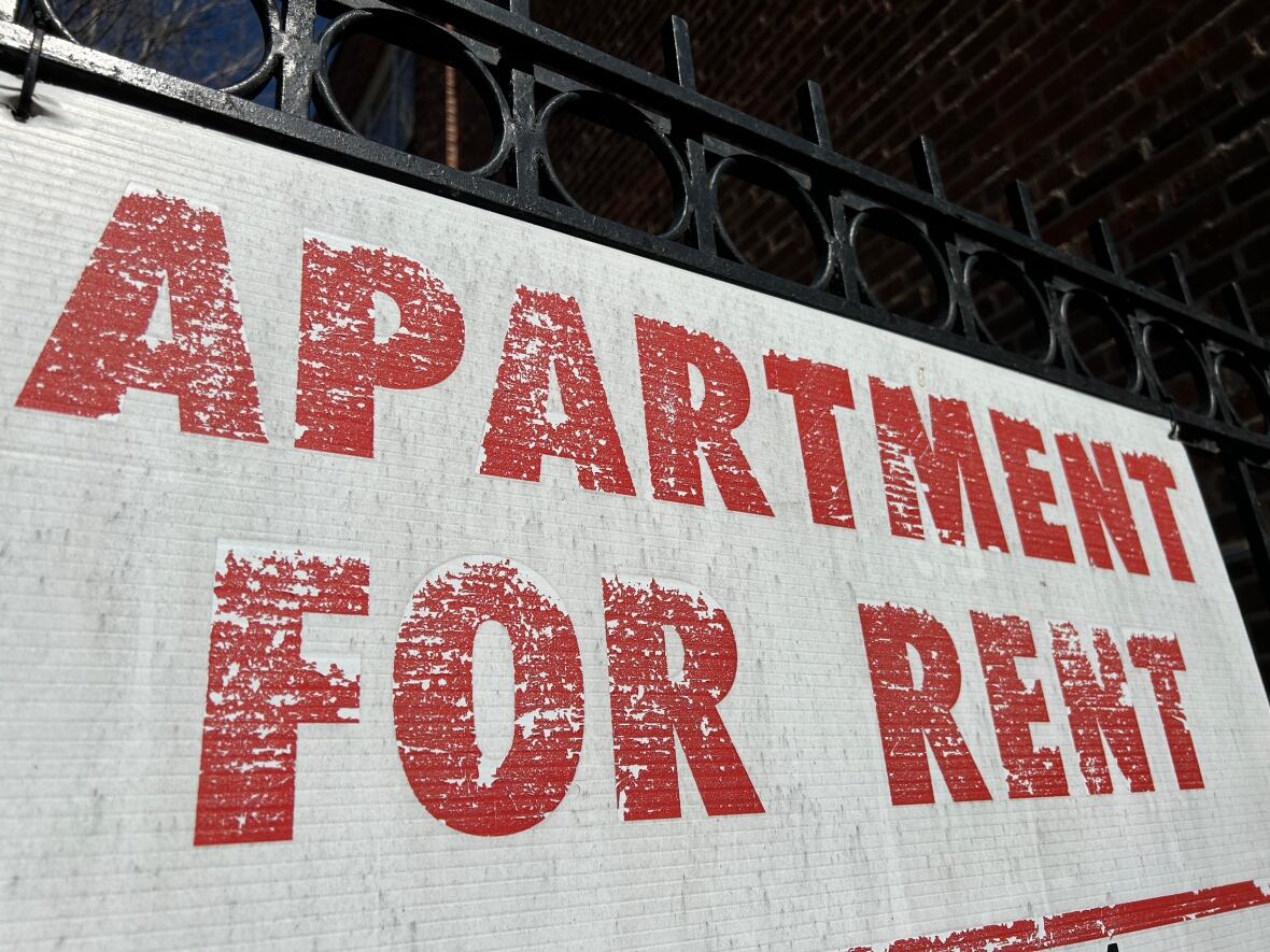 A white sign with worn out red letters says "apartment for rent"