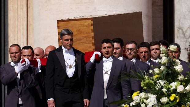 VATICAN CITY, VATICAN - APRIL 26: Pallbearers carry the coffin during the funeral of Pope Francis in St. Peter’s Square on April 26, 2025 in Vatican City, Vatican. Pope Francis died on April 21st at the age of 88. Born in Argentina as Jorge Mario Bergoglio, he was the first Latin American and the first Jesuit to become Pope when elected in 2013. Taking the name Francis after St Francis of Assisi, he promoted a more humble version of the papacy than many of his predecessors. He will be buried outside of the Vatican in a simple wooden coffin at the Basilica Santa Maria Maggiore. (Photo by Franco Origlia/Getty Images) Men carry a wooden coffin.