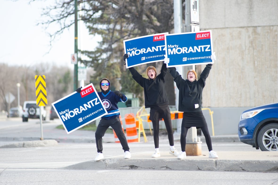 Three radical   clasp  Marty Morantz signs astatine  an intersection. Two of them are yelling.