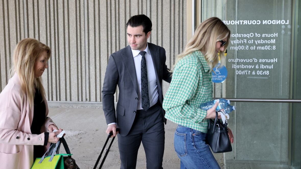 A man and two women enter a building