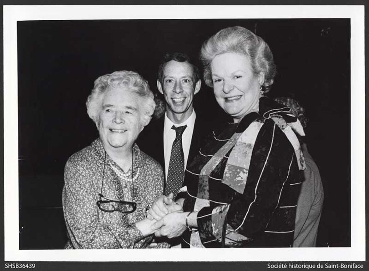 Two women holding hands and a antheral   basal   unneurotic  looking astatine  the camera.
