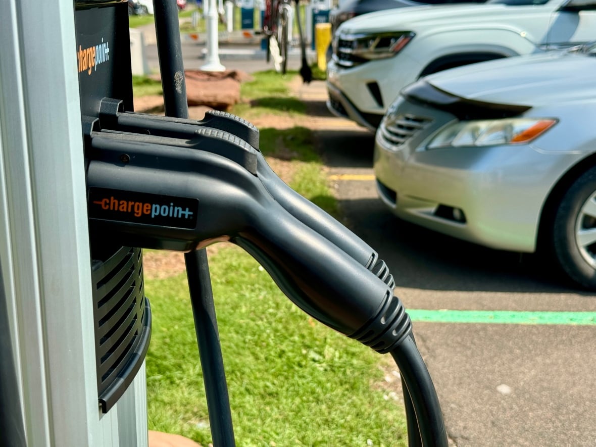 Carregadores de veículos elétricos em primeiro plano e veículos em segundo plano