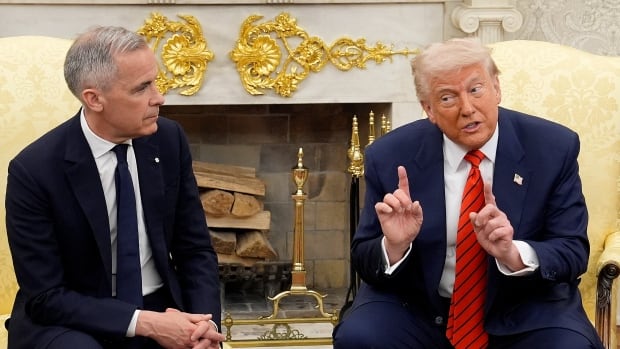 Two men sit in an ornate room.