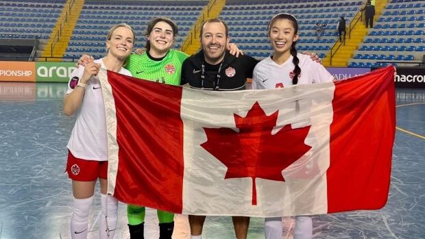 Saskatchewan's, Erica Hindmarsh, Jadyn Steinhauer, Jade Houmphanh and Jenson Barandica-Hamilton smile as they raise the Canadian flag after their 8-2 win over Panama.