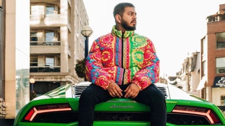Man sitting on the back of a green Lamborghini.