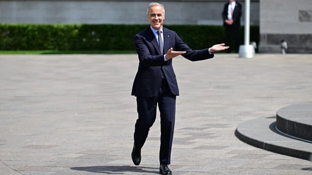 Man makes a gesture to his left while walking.