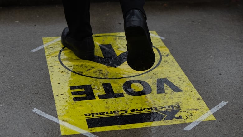 A person walks over an Elections Canada sign.