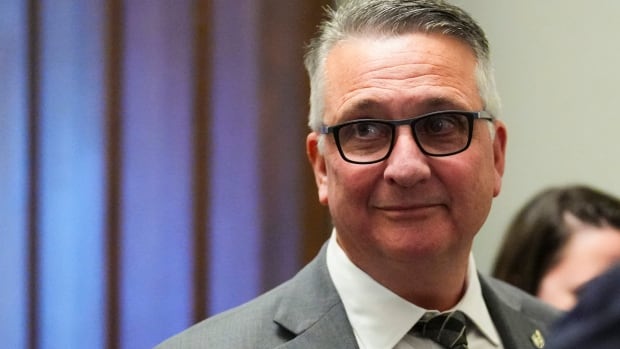 A man with glasses in a suit.