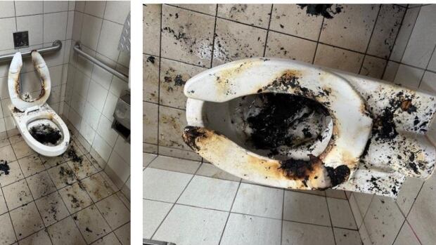 A toilet that is covered by soot and dirt.