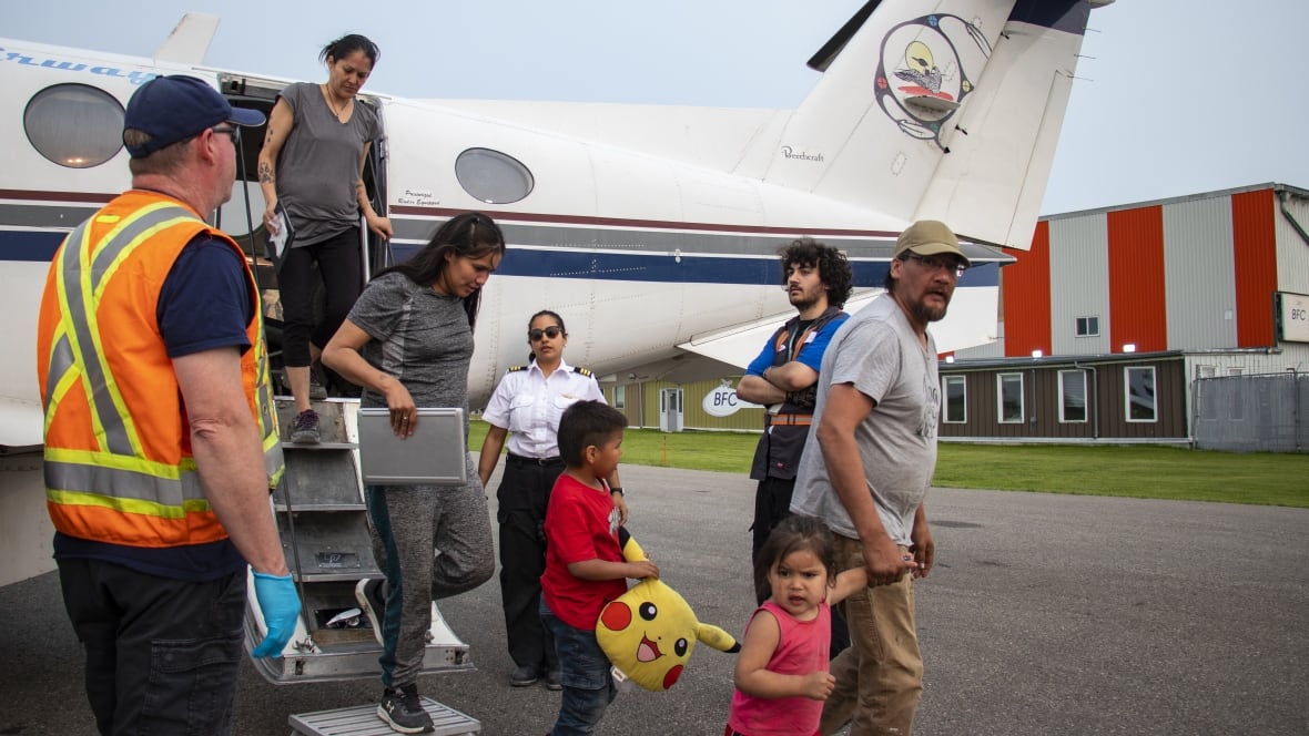 A group of people get off a plane.