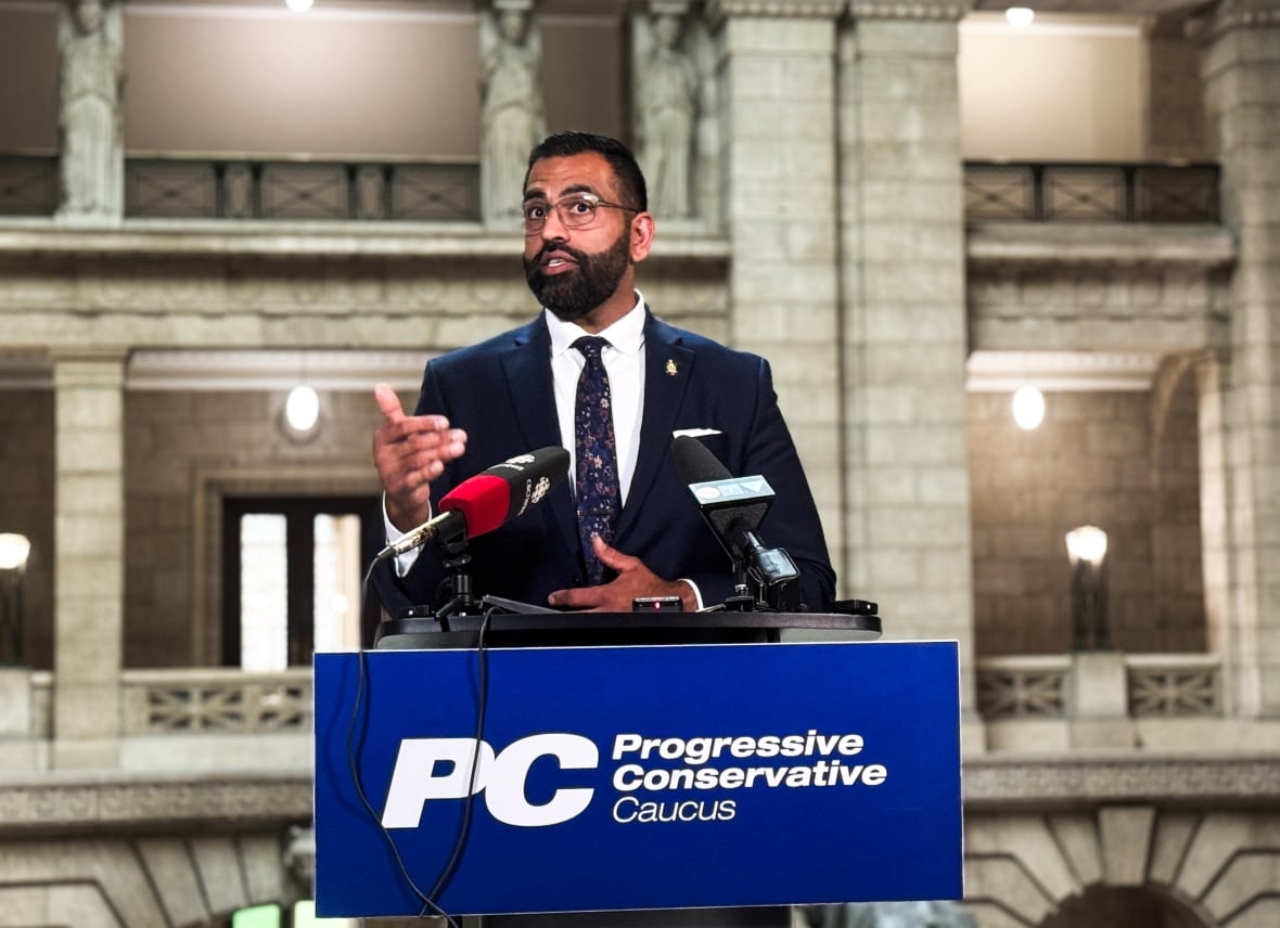 A man in a suit standing behind a podium.