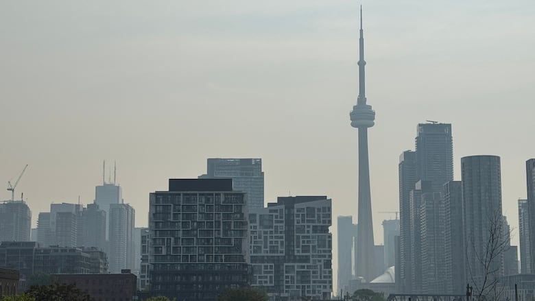 Photo showing the Toronto skyline, including the CN Tower, with a haze of smoke in the sky.