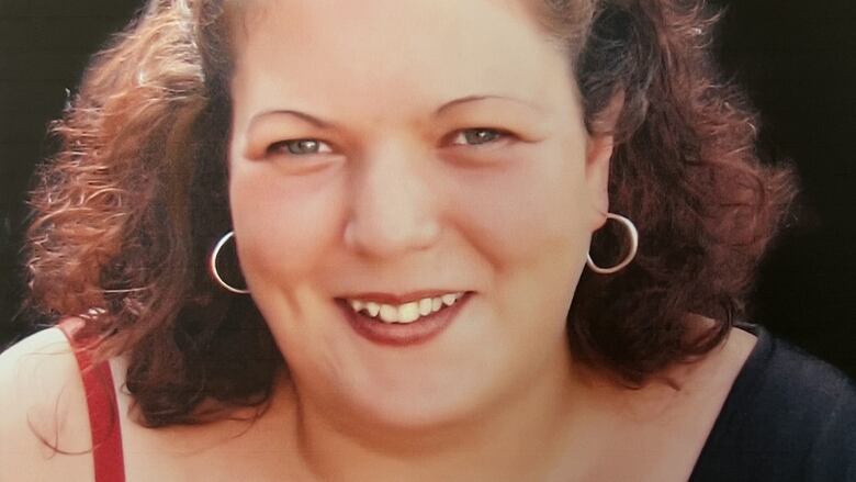 A smiling curly-haired woman.