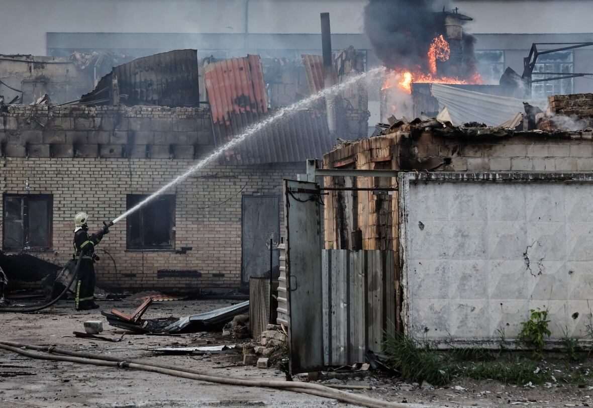 Los bomberos agarraron una manguera y rociaron un edificio en un incendio.