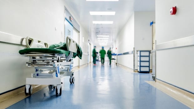 Doctors and nurses walking in hospital hallway, blurred motion