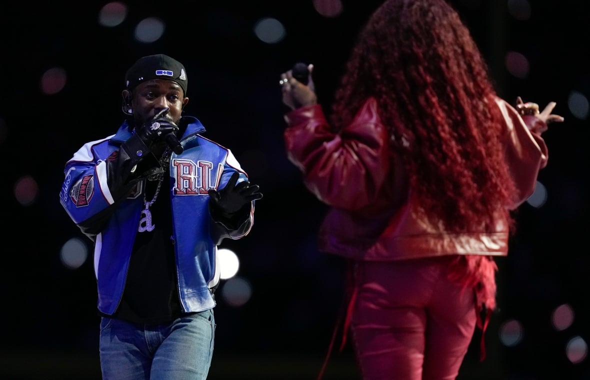 Man performing with microphone in hand, while facing a woman.