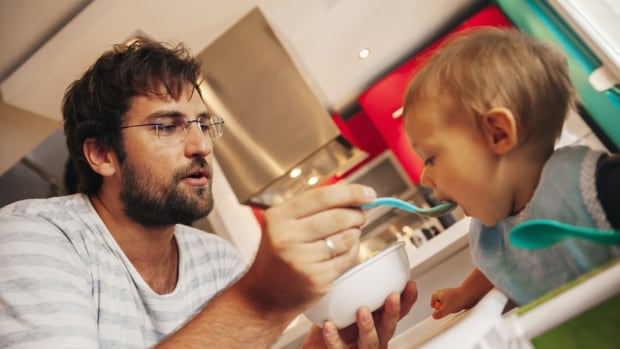 Father feeding baby son.