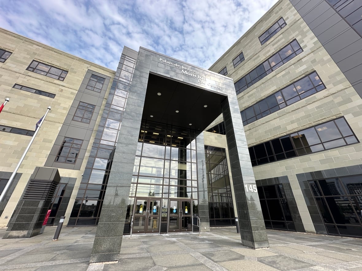 A multi-storey building clad in dark stone and glass.