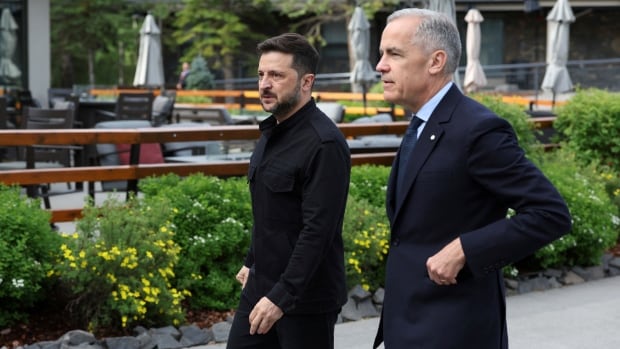 Two men walk outside.