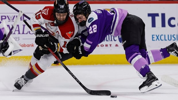 Ottawa Charge forward Brianne Jenner and Minnesota Frost defenceman Natalie Buchbinder battle for the puck during the first period of Game 3 of the PWHL Finals on May 24, 2025, in St. Paul, Minnesota. 