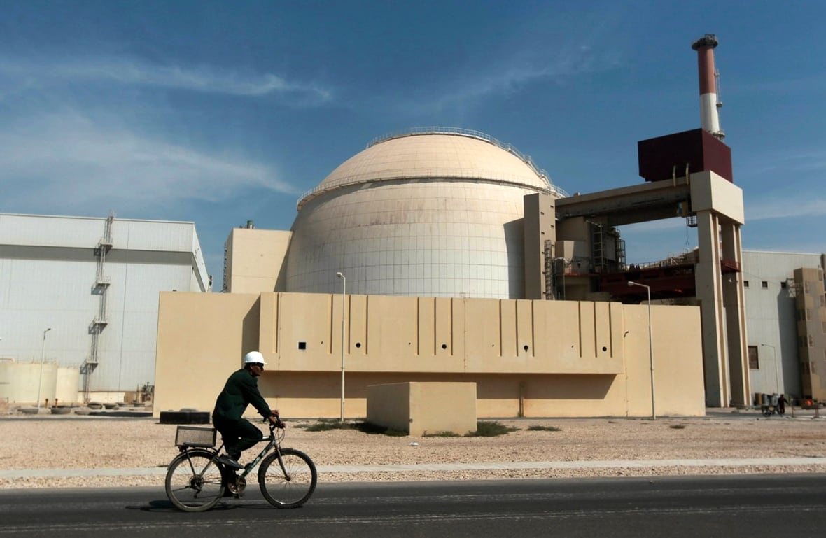 A man riding a bicycle in front of nuclear area