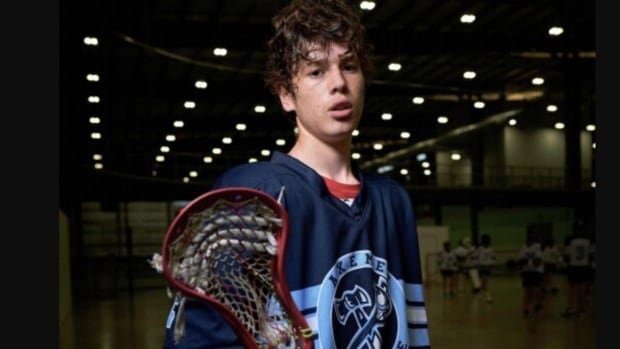 A teenage boy in lacrosse gear.