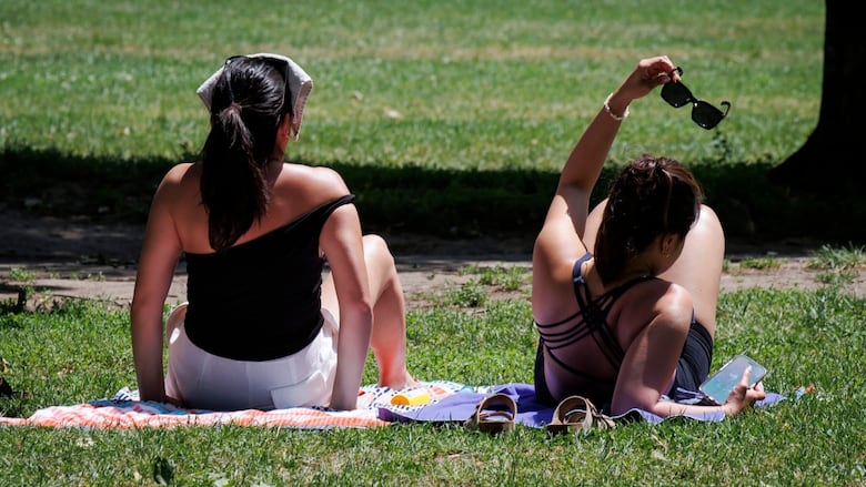 Photo showing two women sitting on grass 