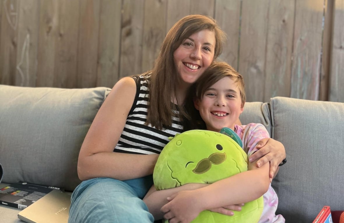 A woman embraces a smiling child outside