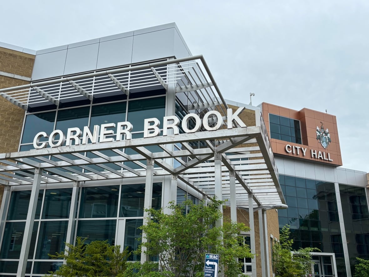 A large brick building with signs that read Corner Brook and City Hall.
