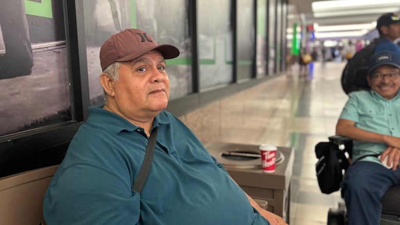 man sits on bench in mall