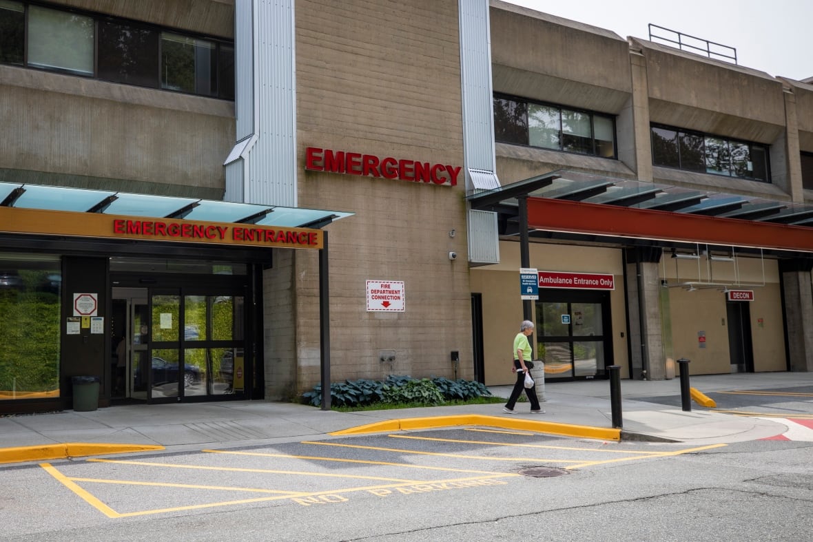 The outside of a long, low two-storey, concrete structure with the words, Emergency, over the entrance.