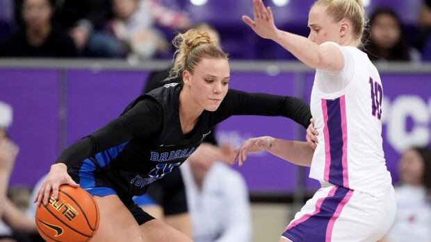 A basketball player is defended.