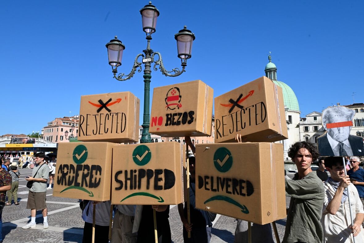 Protesters hold up boxes with slogans written on them.