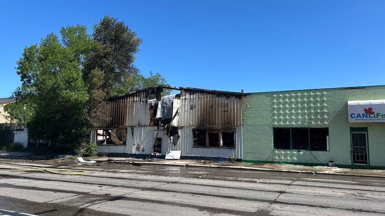 A white building is seen with fire damage. 