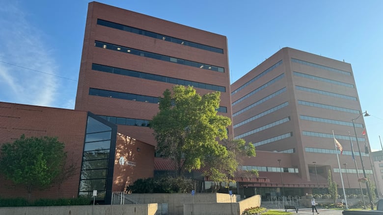Two square 9-story brown buildings located next to each other, and also connected to each other. 