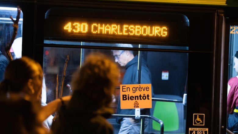 the side of the bus, showing its door and people on board