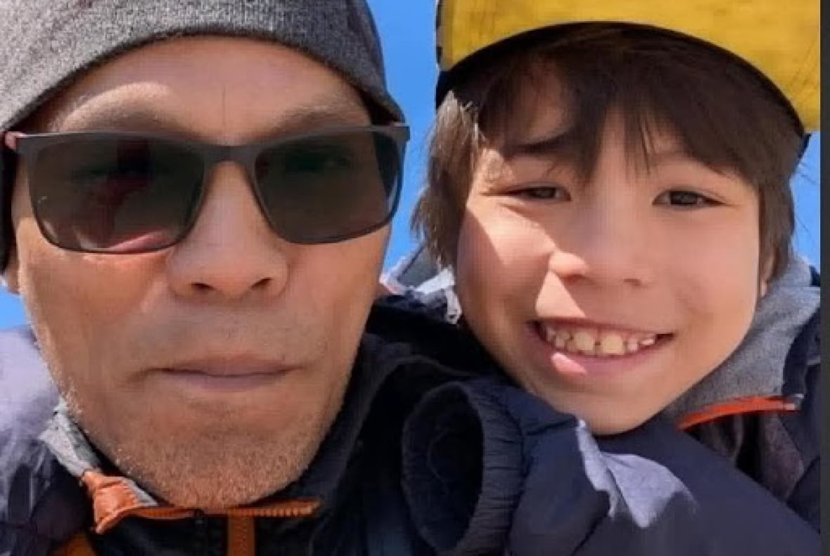 A man and a boy smile.