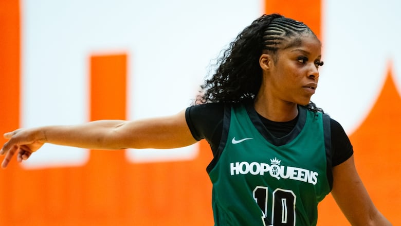 A women's basketball player points on the court during a game.