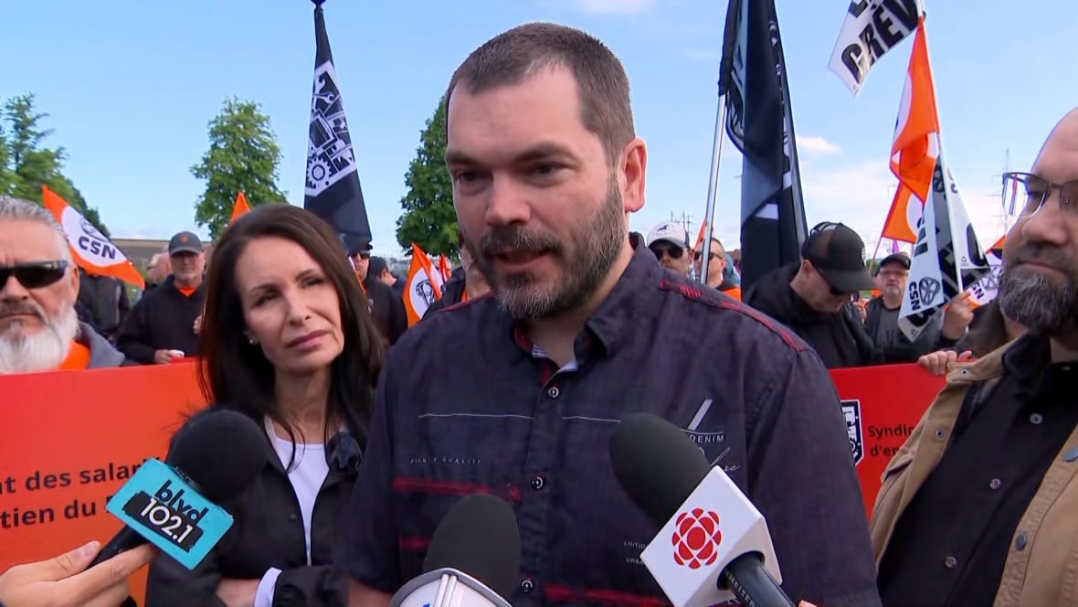 A man stands in front of microphones