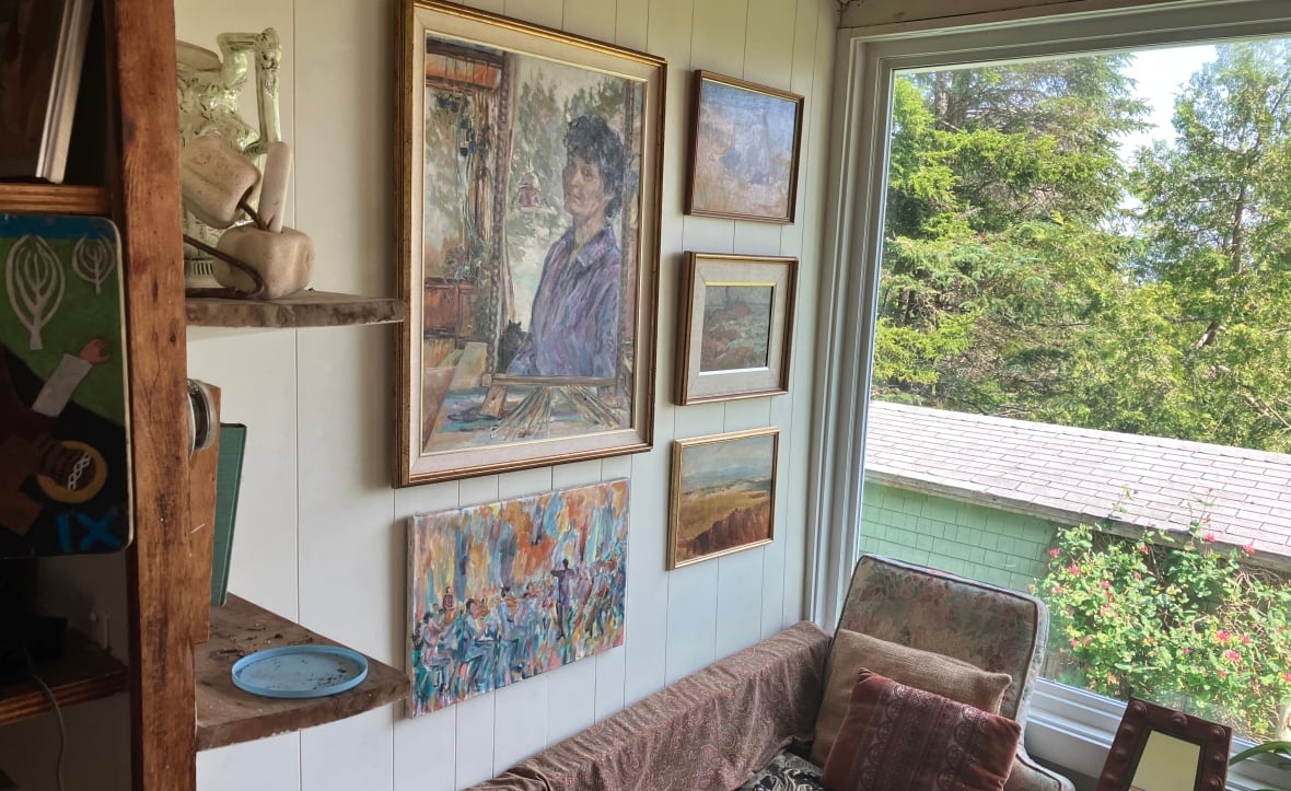 Five paintings hanging between a shelf and window in a local painter's gallery/house.