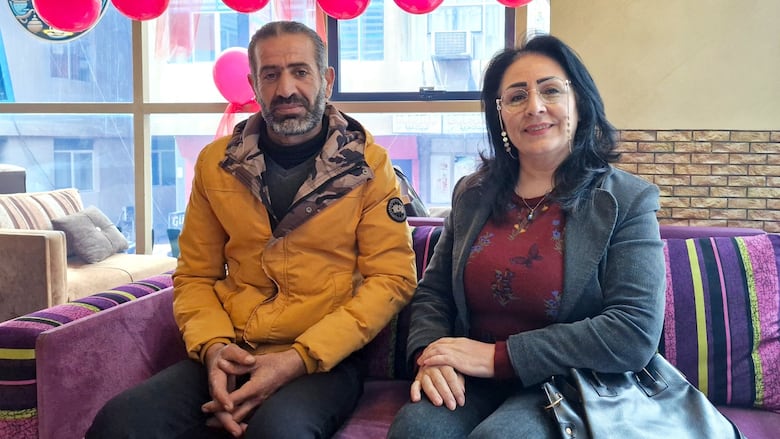 A man and a woman are seated in a restaurant.