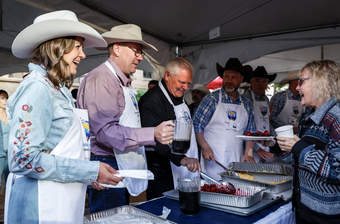 Alberta Premier Danielle Smith, left, Saskatchewan Premier Scott Moe, centre,  and Ontario Premier Doug Ford work in the serving line at the Alberta premier's annual Stampede breakfast in Calgary, Alta., Monday, July 7, 2025.THE CANADIAN PRESS/Jeff McIntosh